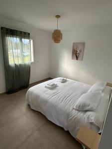 a bedroom with a white bed and a window at Résidence A Traggina in Prunelli-di-Fiumorbo