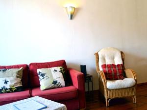 a living room with a red couch and a chair at Comme chez Mamie Albi - Terrasse - Proche Centre in Albi