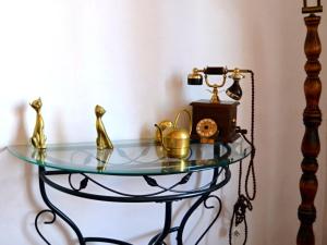an old fashioned glass table with a clock and a tea kettle at Comme chez Mamie Albi - Terrasse - Proche Centre in Albi +28 photos