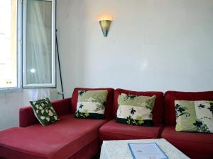 a living room with a red couch with pillows at Comme chez Mamie Albi - Terrasse - Proche Centre in Albi