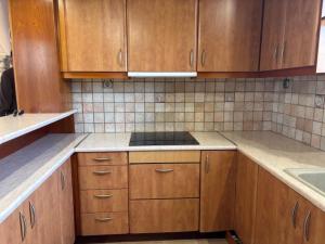 a kitchen with wooden cabinets and a stove top oven at Dream Village Mani in Karvelás