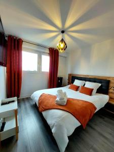 a bedroom with a large bed with red curtains at Appartement à Limoges, proche CHU in Limoges