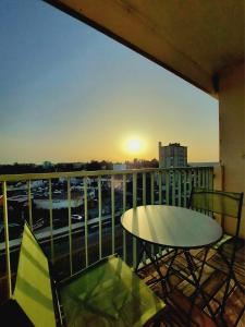 a table and chairs on a balcony with the sunset at Appartement à Limoges, proche CHU in Limoges