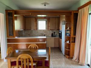 a kitchen with a table and chairs and a refrigerator at Dream Village Mani in Karvelás