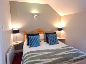 a bedroom with a bed with blue pillows and two lamps at Aran View Loft in Knockfin Cross Roads