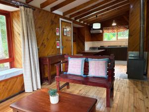 a living room with a bench and a table at Cabañas y Domos Calafquen in Coñaripe