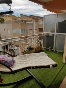 a bed on the balcony of a apartment at Duplex en El Pouet, con ascensor in Sueca