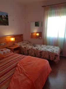 a hotel room with two beds and a window at Duplex en El Pouet, con ascensor in Sueca +7 photos