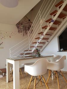 a dining room with a white table and stairs at Duplex en El Pouet, con ascensor in Sueca