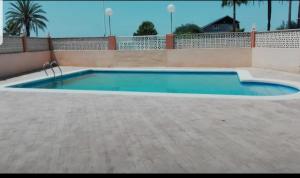 a large swimming pool in a yard with a fence at Duplex en El Pouet, con ascensor in Sueca
