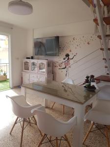a dining room with a table and white chairs at Duplex en El Pouet, con ascensor in Sueca