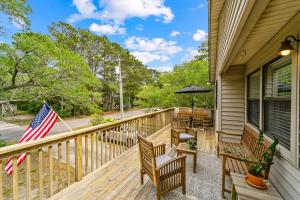 a deck with benches and an american flag at Sea Swept Cottage OBX in Kill Devil Hills