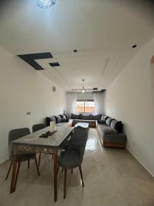 a living room with a table and a couch at appartement confortable in Berkane