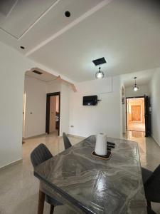 a living room with a table and chairs in a room at appartement confortable in Berkane