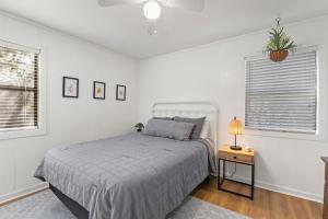 a bedroom with a bed and a table with a lamp at Sea Swept Cottage OBX in Kill Devil Hills