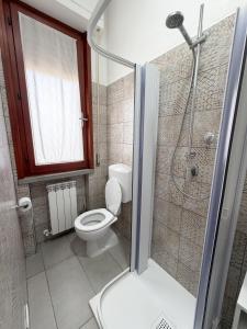 a bathroom with a toilet and a shower with a glass door at Da Vinci Rooms in Vinci
