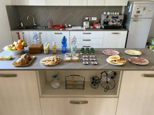 a kitchen counter with plates of food on it at Cygnus Bed & Breakfast in Lido di Jesolo +14 photos