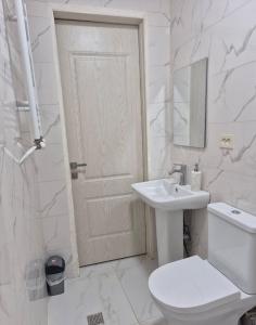 a white bathroom with a toilet and a sink at Guest House Aspindza in Aspindza