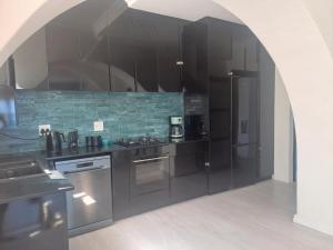 a kitchen with black cabinets and stainless steel appliances at 210 on Main in Kalk Bay
