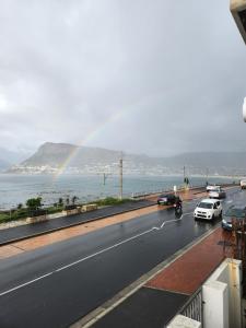 a rainbow on the side of a road with cars at 210 on Main in Kalk Bay