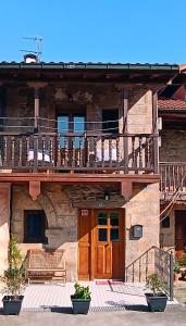 a building with a balcony and a wooden door at Casa el Envero in Saro
