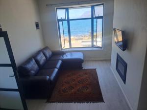 a living room with a couch and a large window at 210 on Main in Kalk Bay