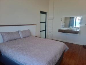a bedroom with a bed and a bathroom with a sink at 210 on Main in Kalk Bay