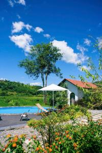 a beach with an umbrella and a bench and a house at Trám House in Cao Phong