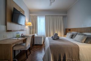 a hotel room with a bed and a desk at Playas Art Hotel in Pinamar +110 photos