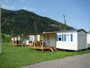 a row of mobile homes in a field with a mountain at Victoria Camping Bella Austria in Peterdorf