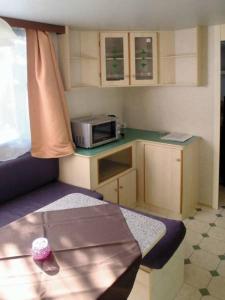 a small kitchen with a table and a microwave at Victoria Camping Bella Austria in Peterdorf