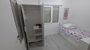 a small bedroom with a bed and a window at Casa Ursula in Los Alcázares