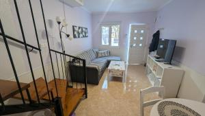a living room with a couch and a tv at Casa Ursula in Los Alcázares