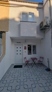 a building with a patio with three chairs and a door at Casa Ursula in Los Alcázares