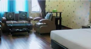 a hotel room with a bed and a couch and chairs at Hotel Permata Inn Ball Room Seroja in Kualakapuas