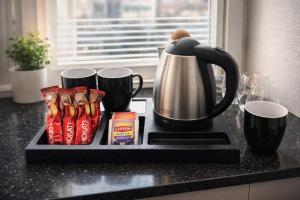 a black counter top with a coffee pot and packets of chips at City Living Trelleborg in Trelleborg