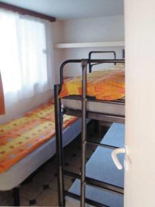 two bunk beds in a room with a window at Victoria Camping Bella Austria in Peterdorf