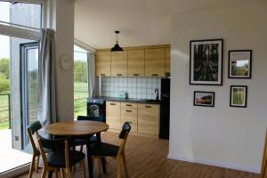 a kitchen and dining room with a table and chairs at Między Jeziorami in Ogonki