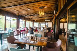 a dining room with tables and chairs and windows at Hotel & Restaurant Carevoselski in Delčevo