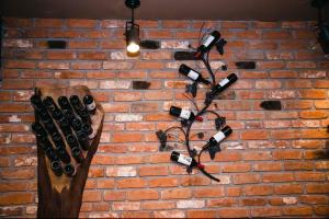 a bunch of wine bottles hanging on a brick wall at Hotel & Restaurant Carevoselski in Delčevo