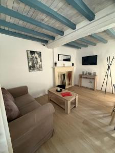 a living room with a couch and a table at La maisonnette in Coulombs