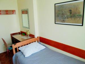a bedroom with a bed and a table with a mirror at Room Zox Gluten-free in Vukovar
