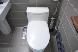 a white toilet in a bathroom with a remote control at RoseBrickHouse in Gwangju +27 photos