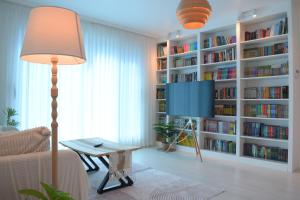 a living room with a book shelf with books at RoseBrickHouse in Gwangju
