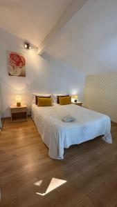 a bedroom with a large bed with yellow pillows at Matsya Hostel in Anglet