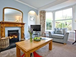 a living room with a fireplace and a table at Tuckenhay, Mill Lodge - Ftd in Ashsprington +38 photos