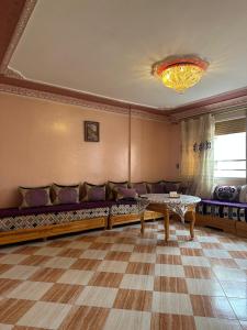 a living room with a couch and a table at Appartement champs élyséen in Berkane