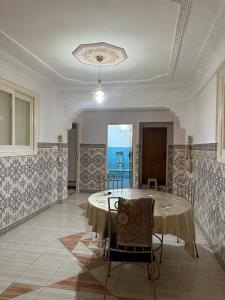 a dining room with a table and chairs in it at Appartement champs élyséen in Berkane