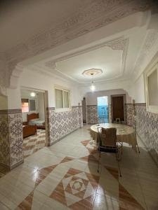 a large room with a table and chairs in it at Appartement champs élyséen in Berkane