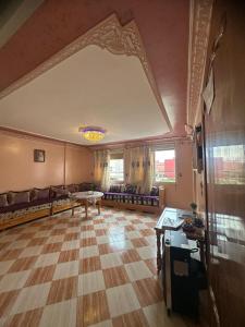 a living room with a couch and a table at Appartement champs élyséen in Berkane